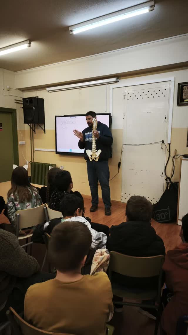 Alejandro explicando una columna vertebral a un aula de escolares