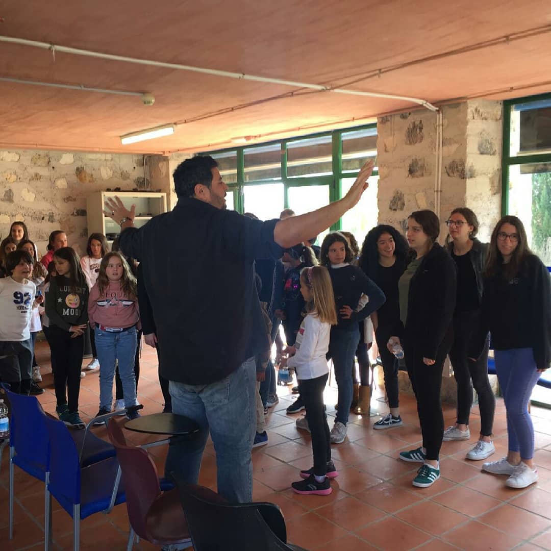 Alejandro dirigiendo un ejercicio postural ante un grupo de alumnos de música