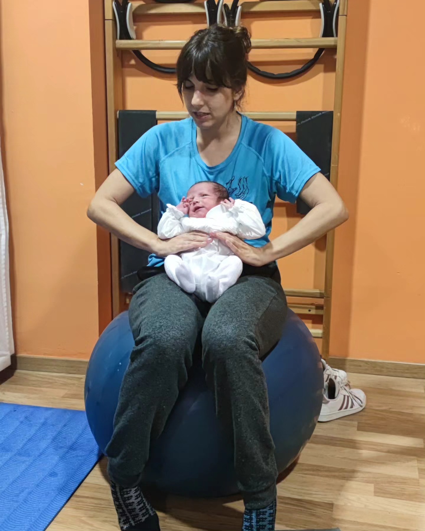 Vanessa sosteniendo a un bebé sobre una pelota durante el taller