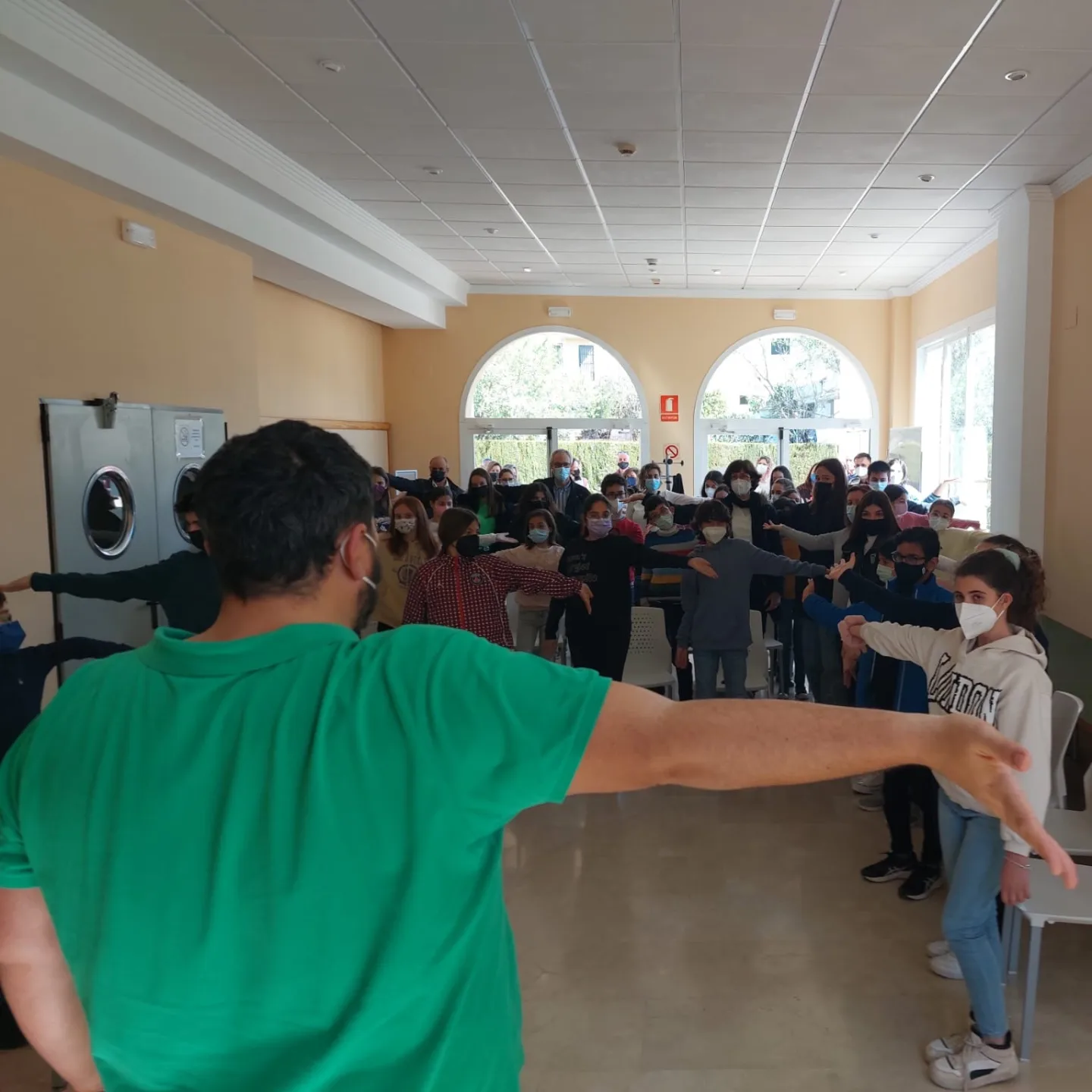 Grupo de alumnos de corda siguiendo un ejercicio de estiramiento en una sala